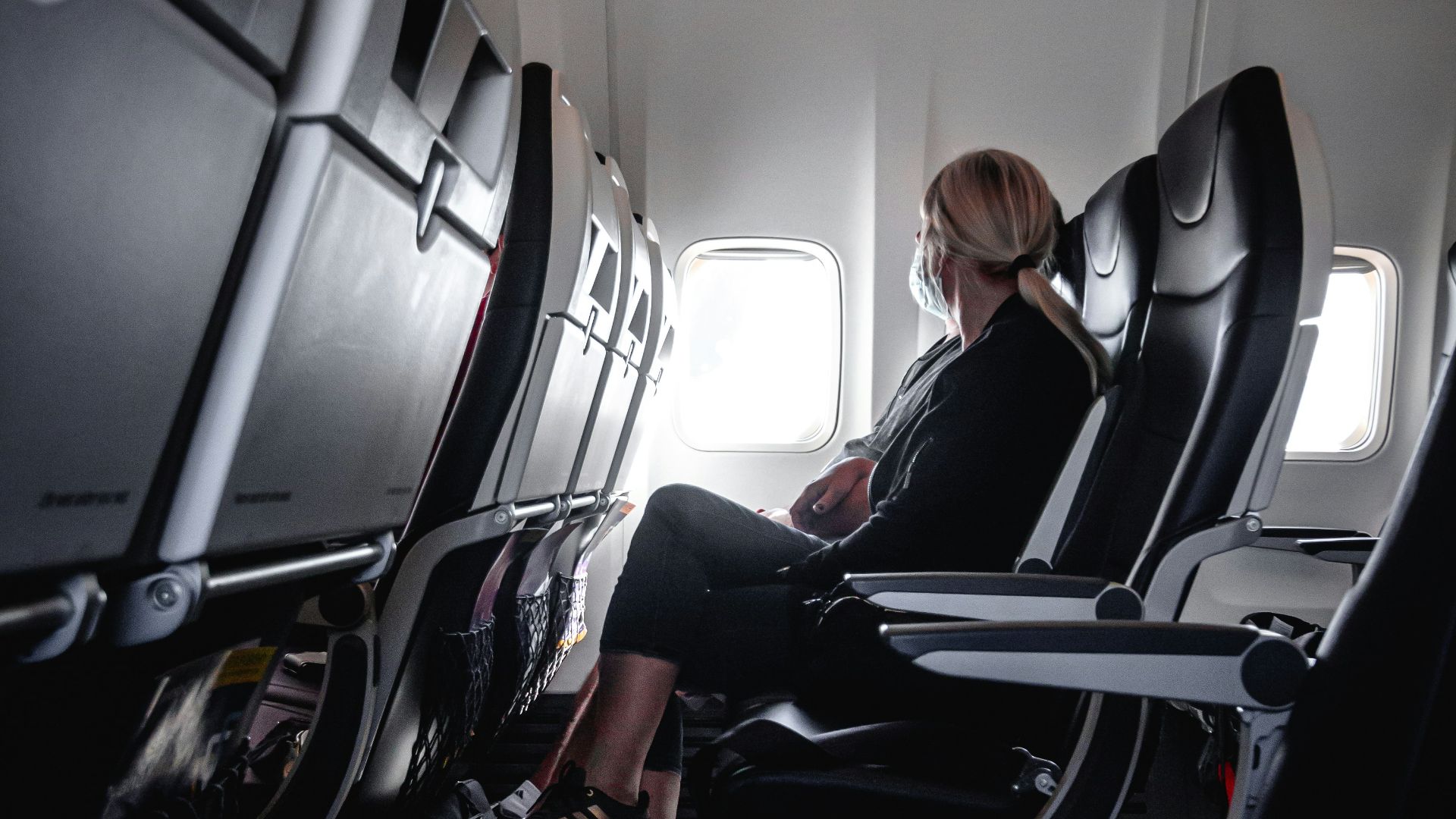 a woman sitting in a seat on an airplane