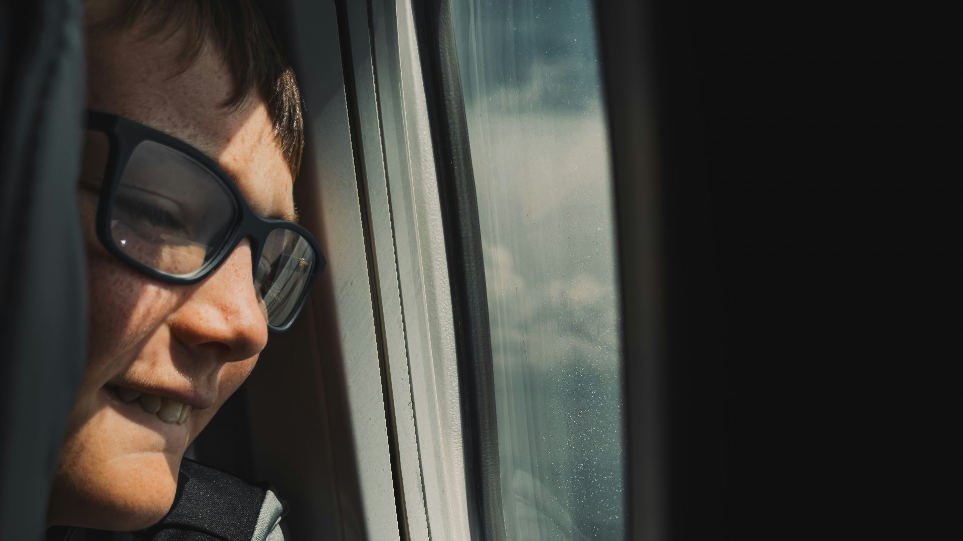 A man looking out the window of an airplane