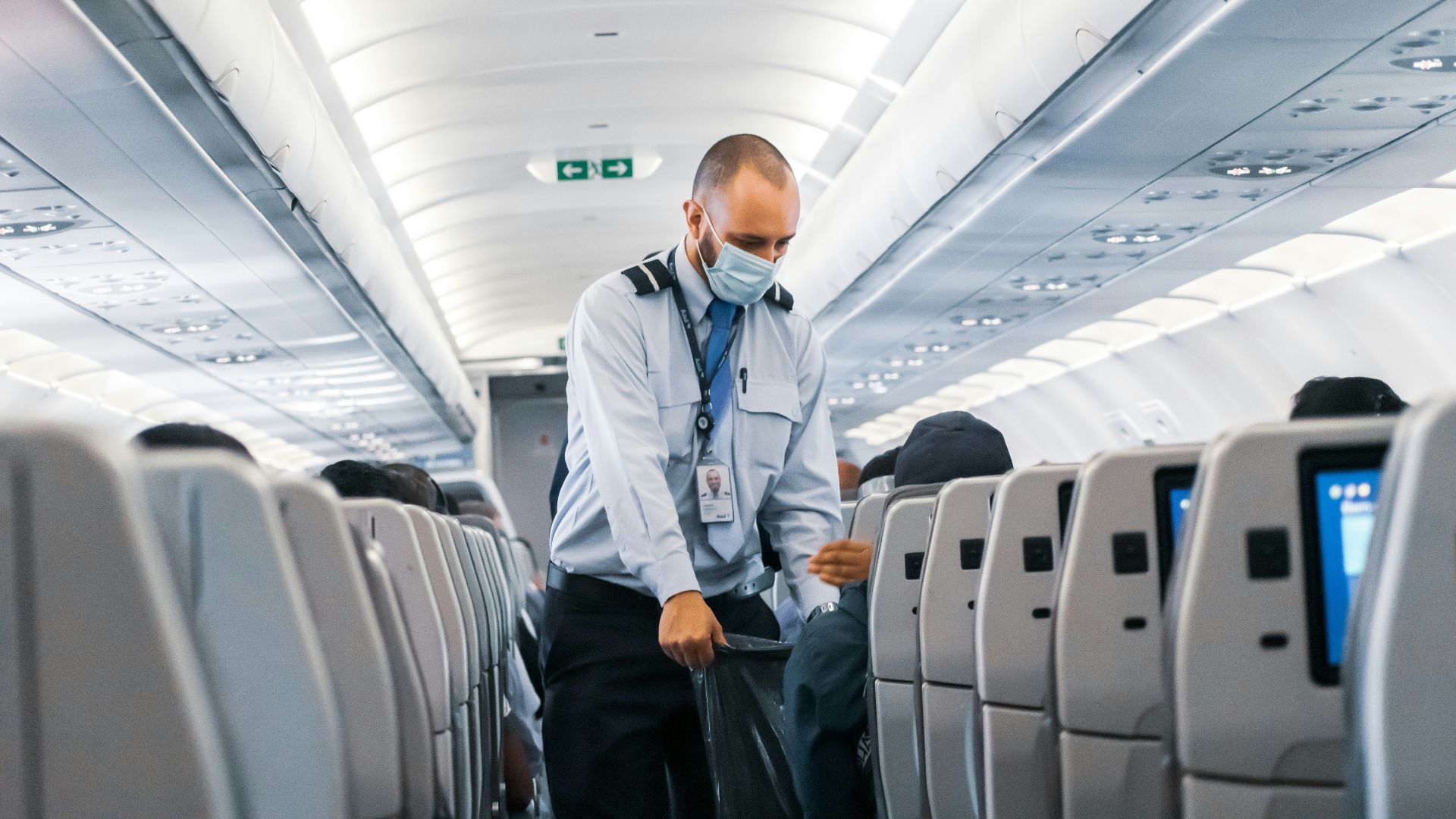 man in blue dress shirt standing in airplane