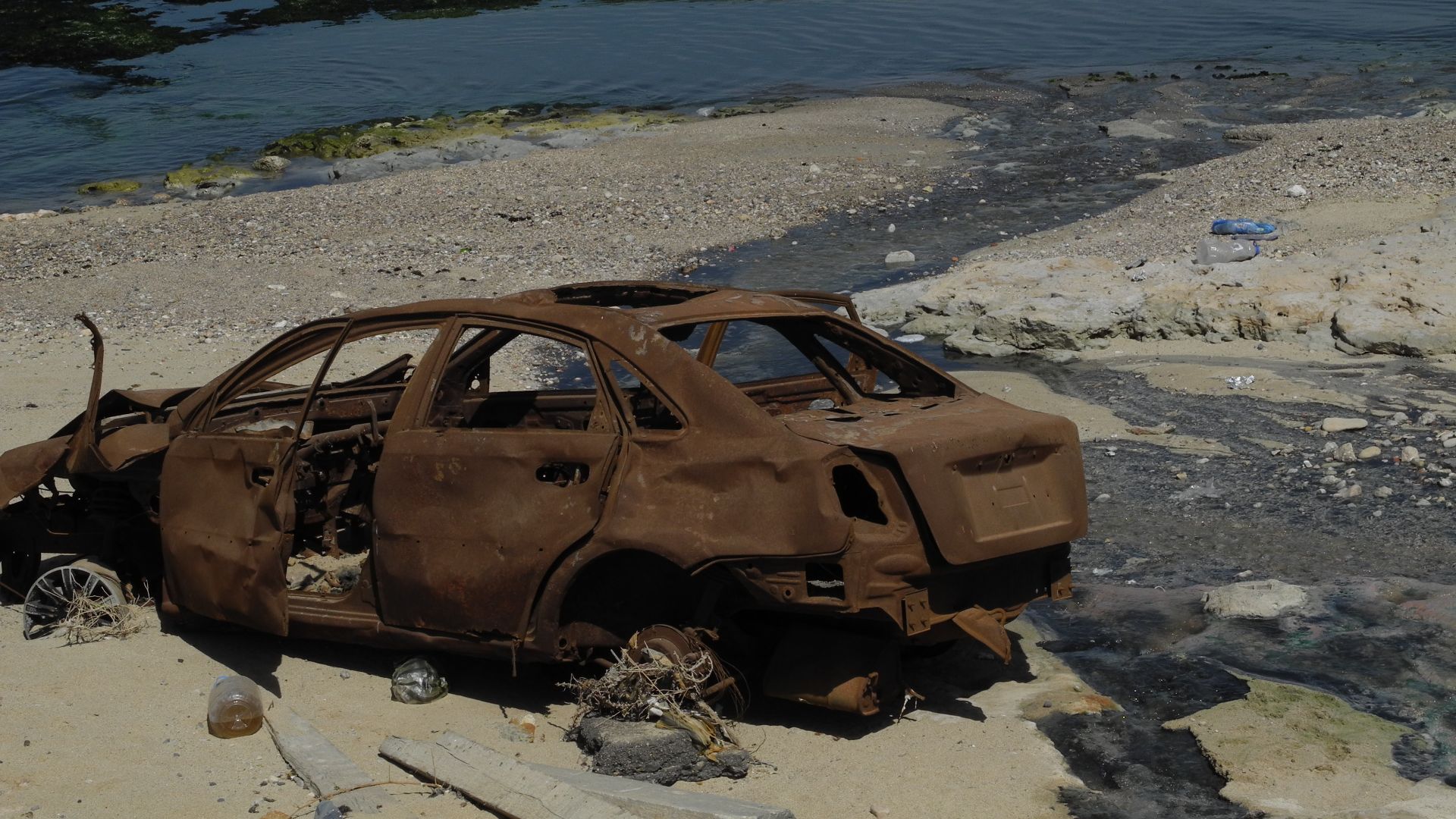 File:The Detritus of War, destroyed auto on a beach in Libya in January 2014.jpg