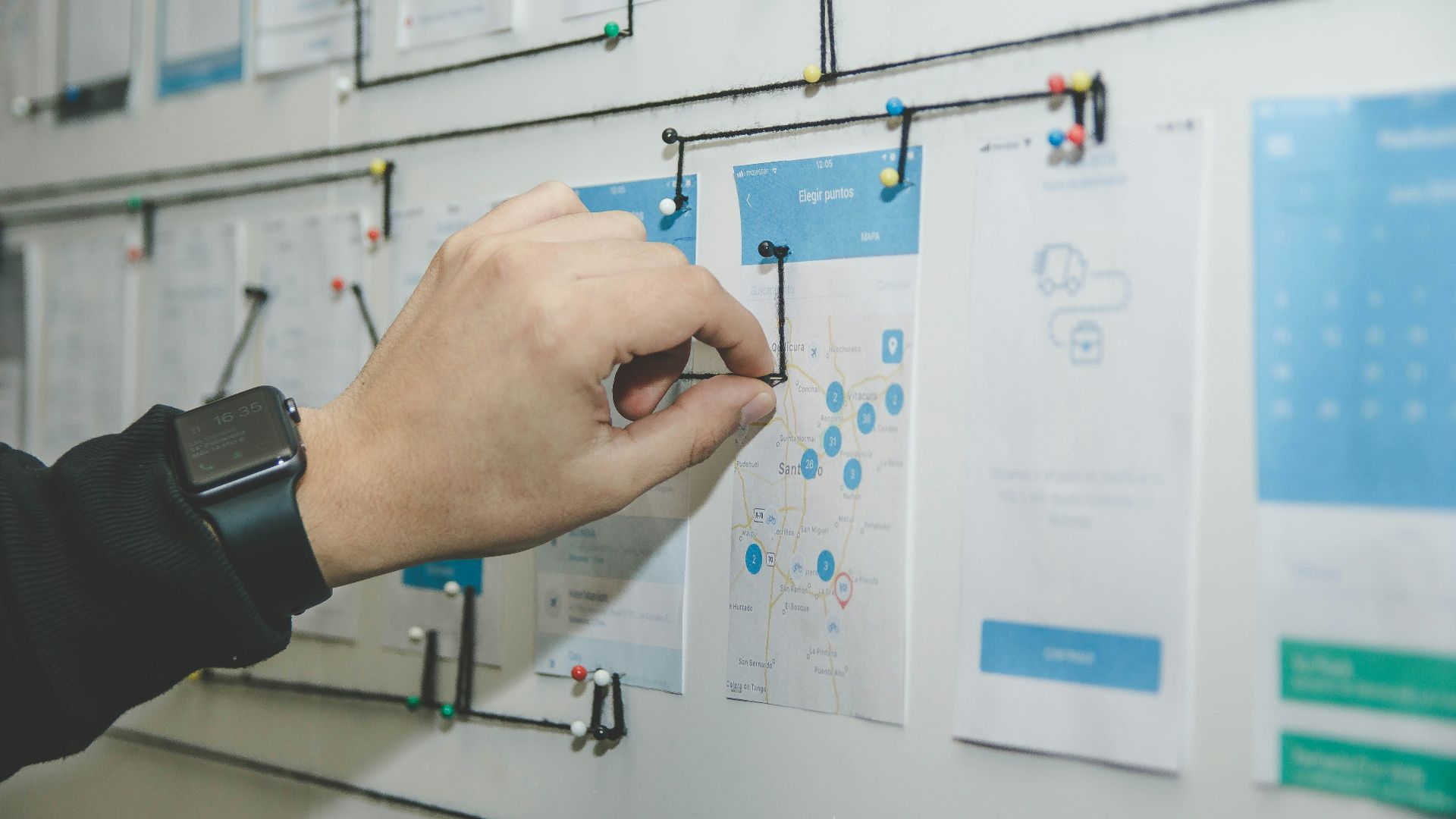 person working on blue and white paper on board