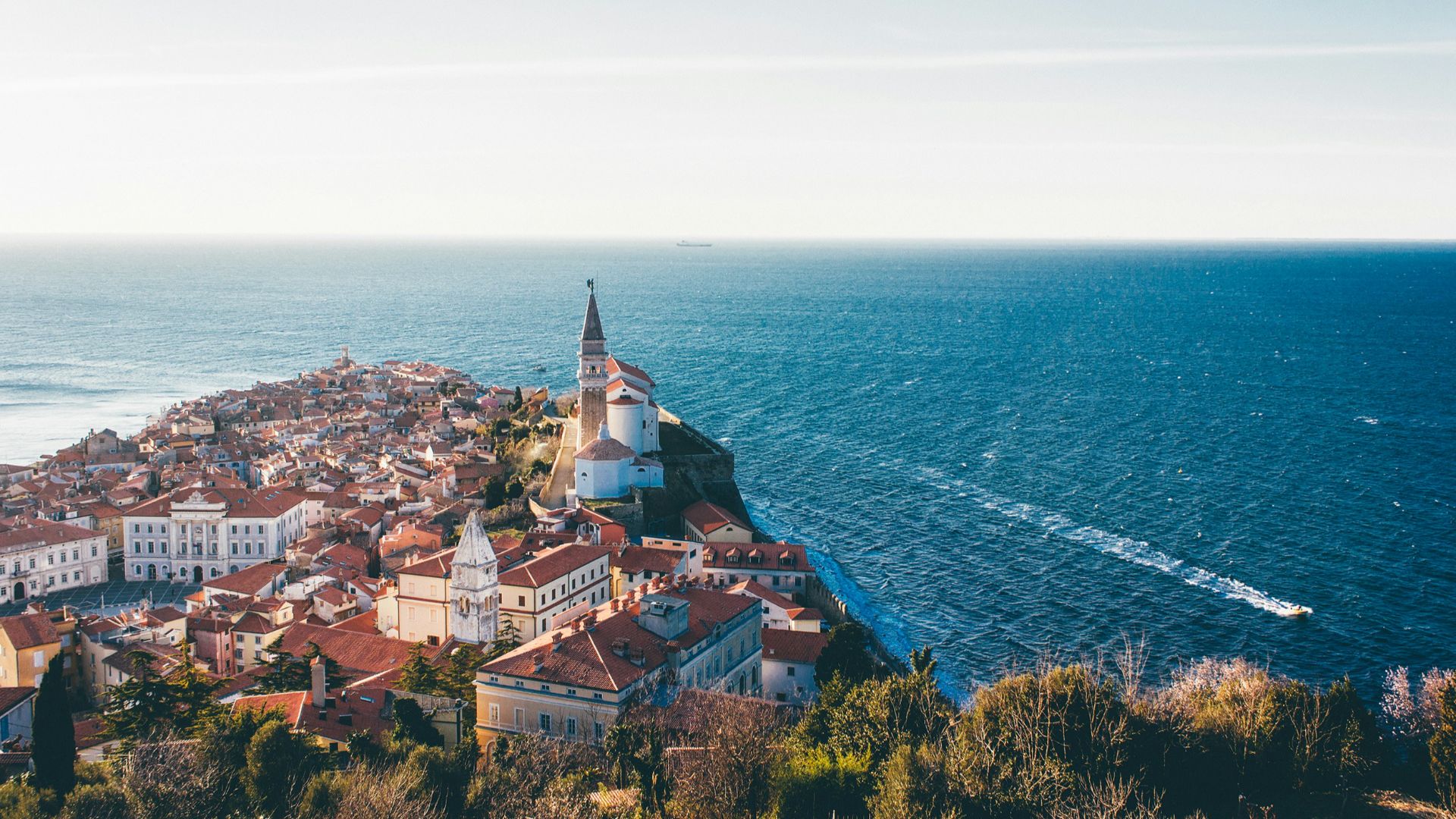 brown roof buildings near sea ocean taken at daytime