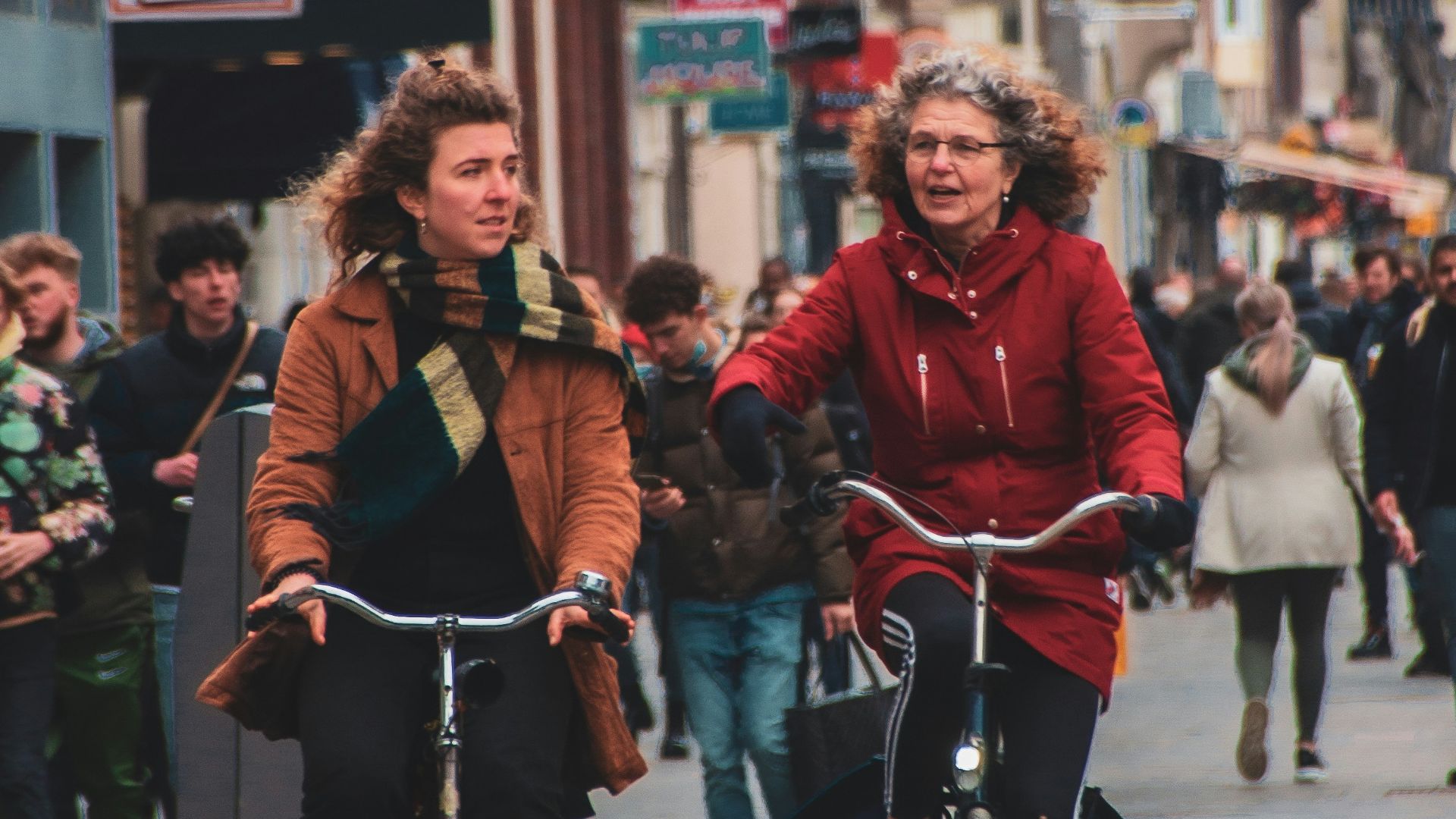 man in red long sleeve shirt riding bicycle on street during daytime
