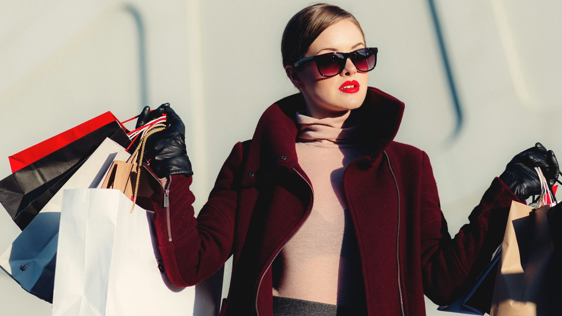 photo of woman holding white and black paper bags