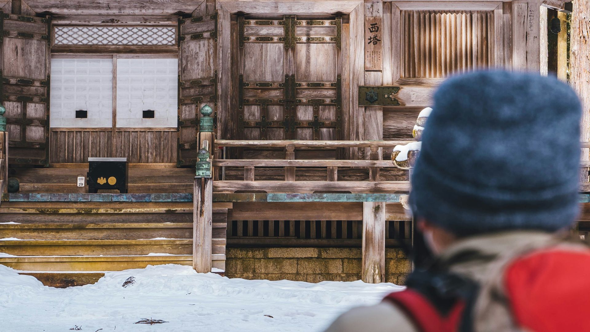 a person standing in front of a building in the snow