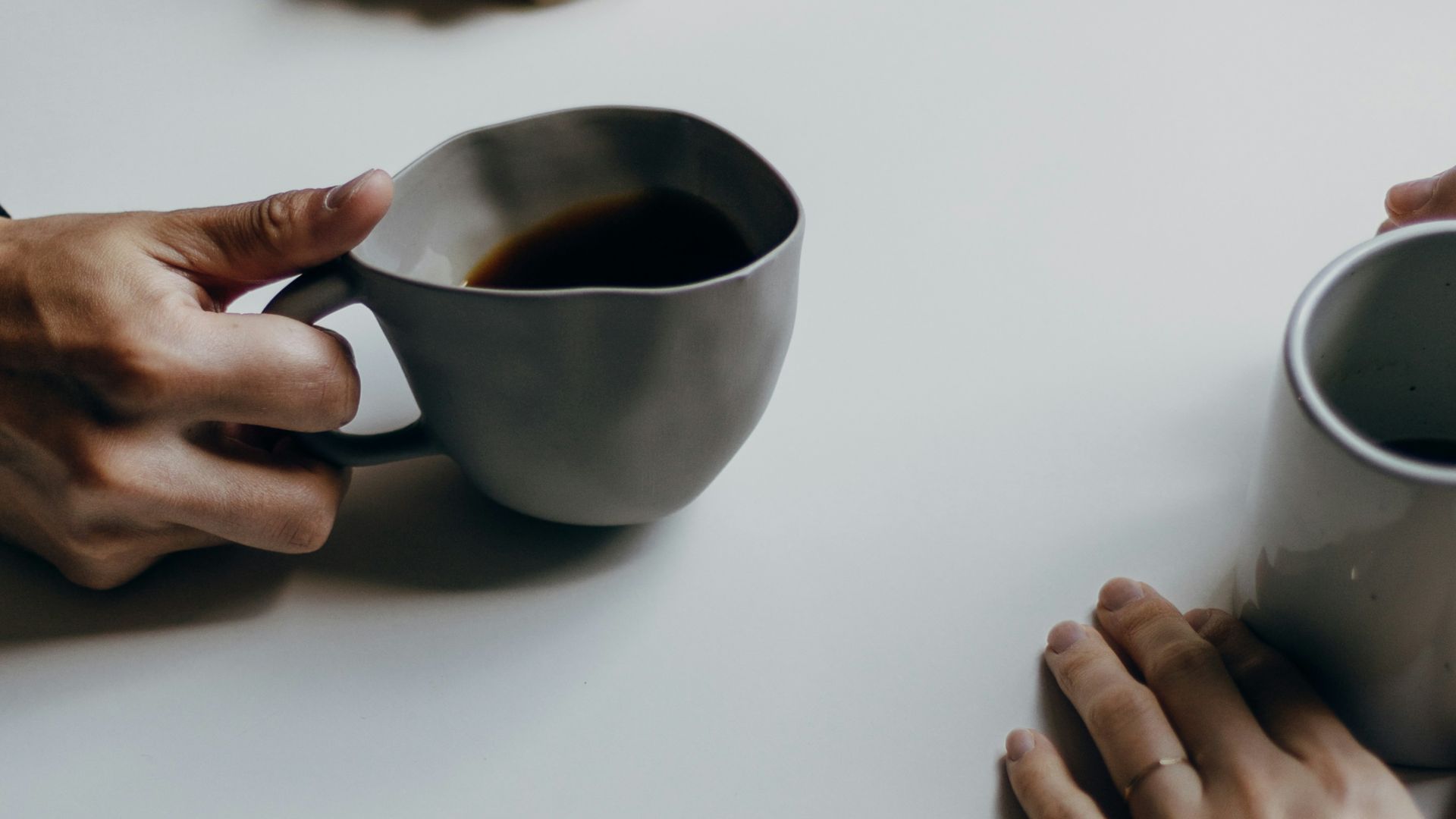 a couple of people sitting at a table with cups of coffee