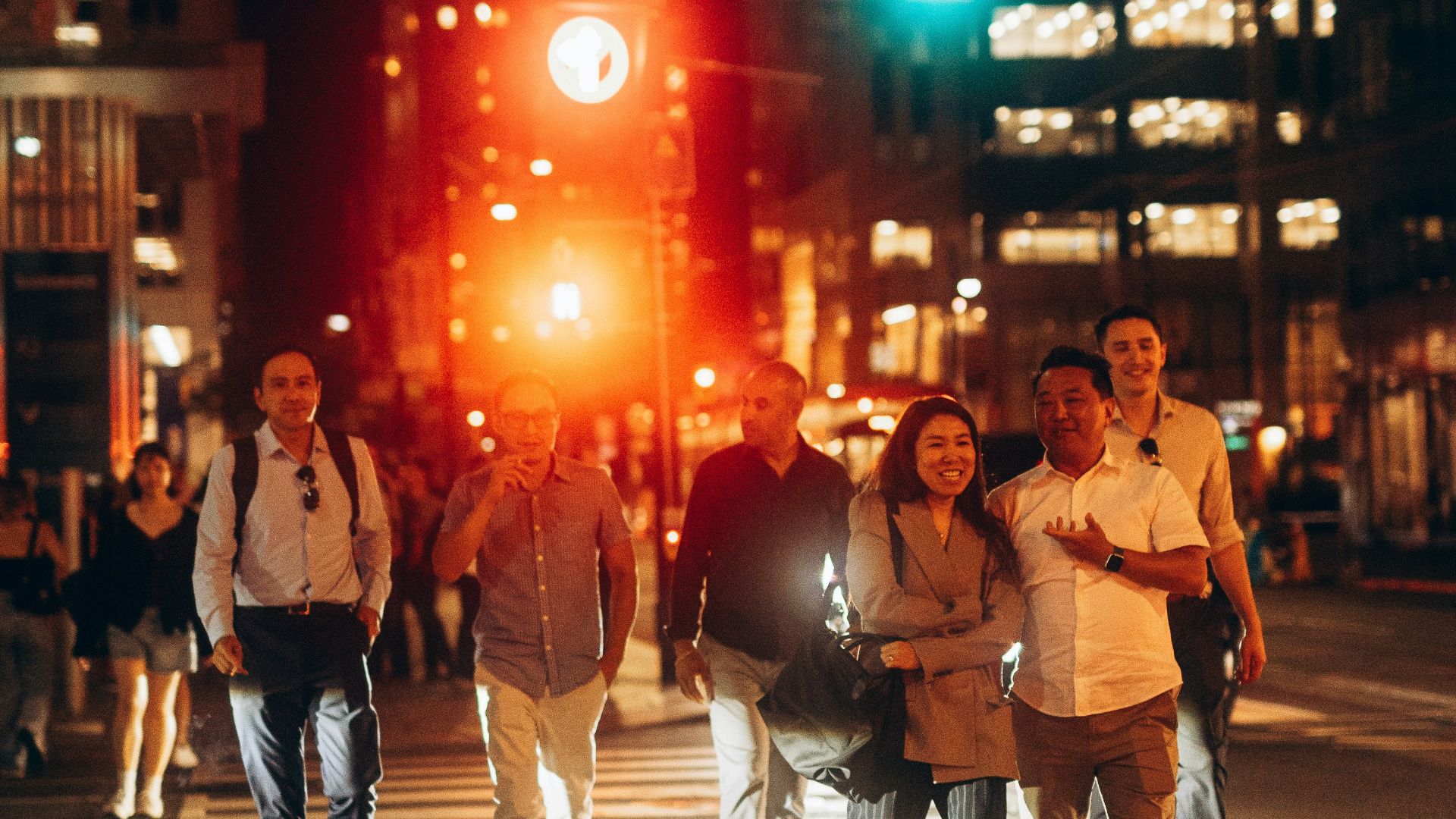 A group of people crossing a street at night