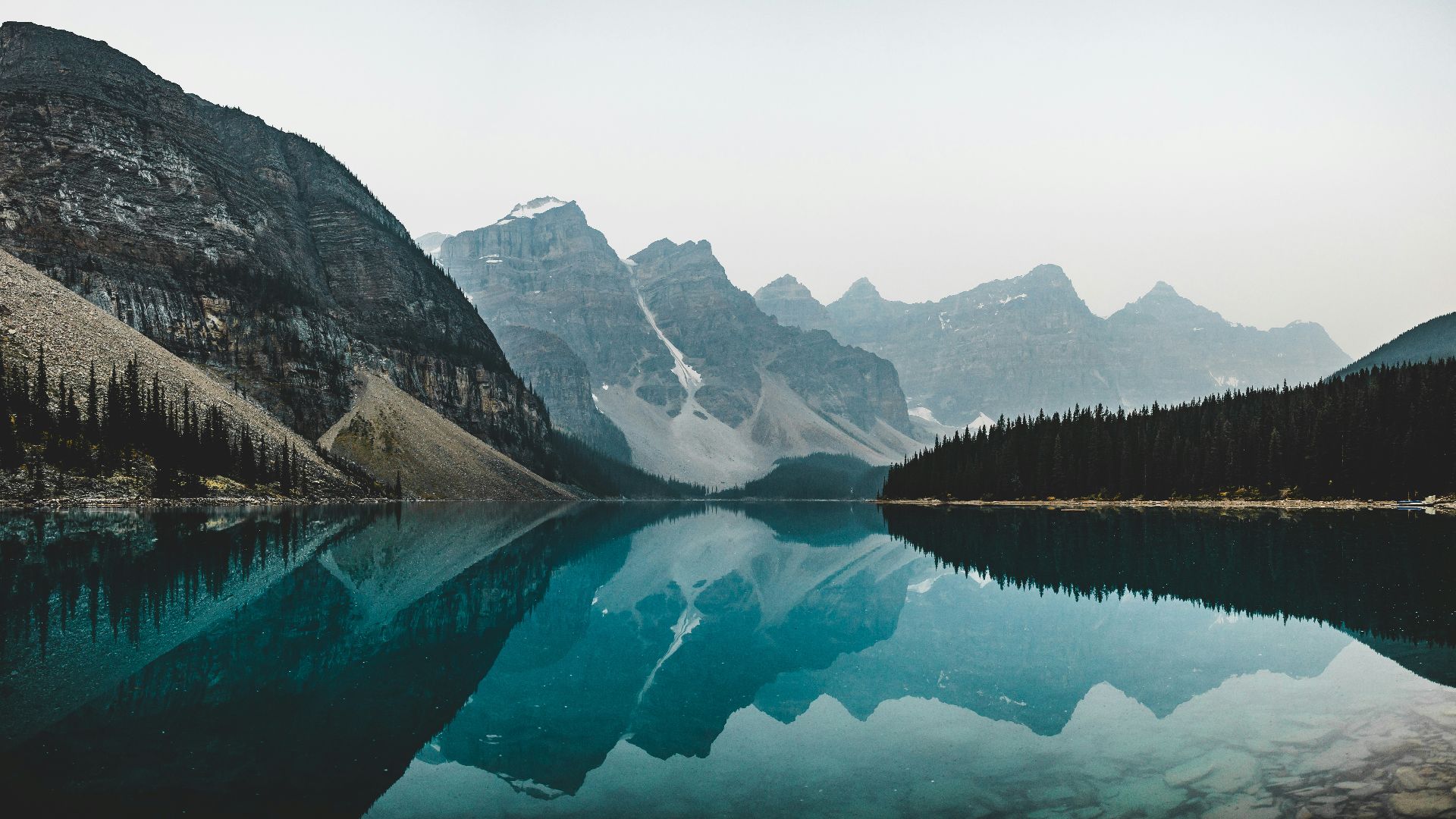 lake near mountain range under blue sky during daytime