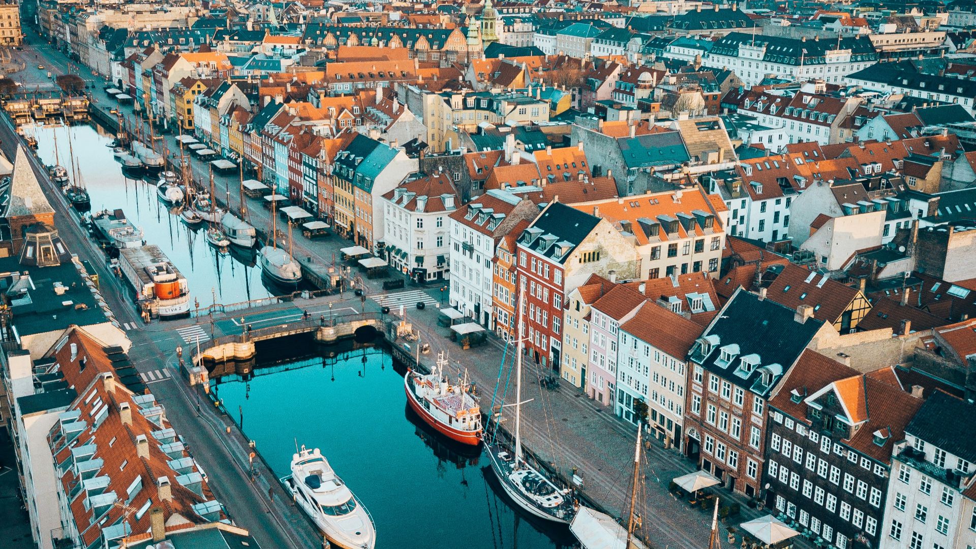 aerial photo of boats in between concrete buildings during daytime