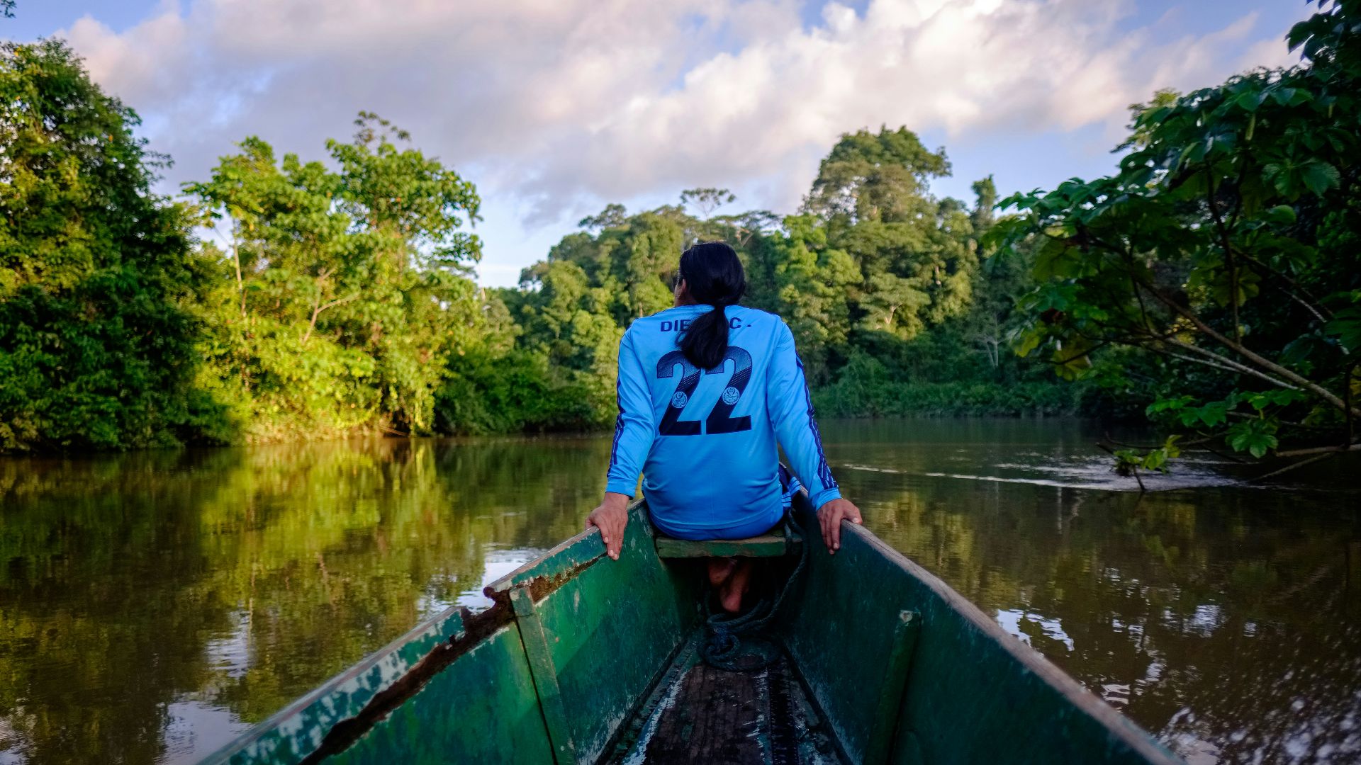 a woman sitting in a boat on a river