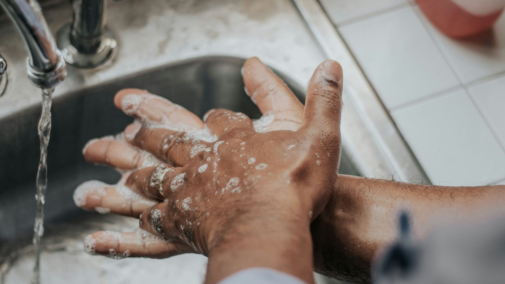 person in white shirt washing hands