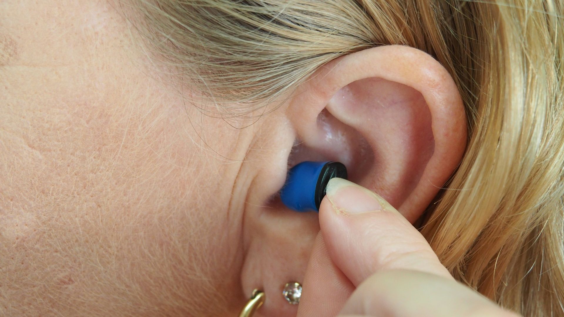 woman wearing blue stud earring