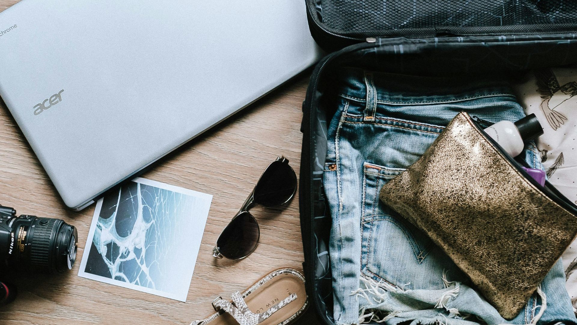 black DSLR camera near sunglasses and bag