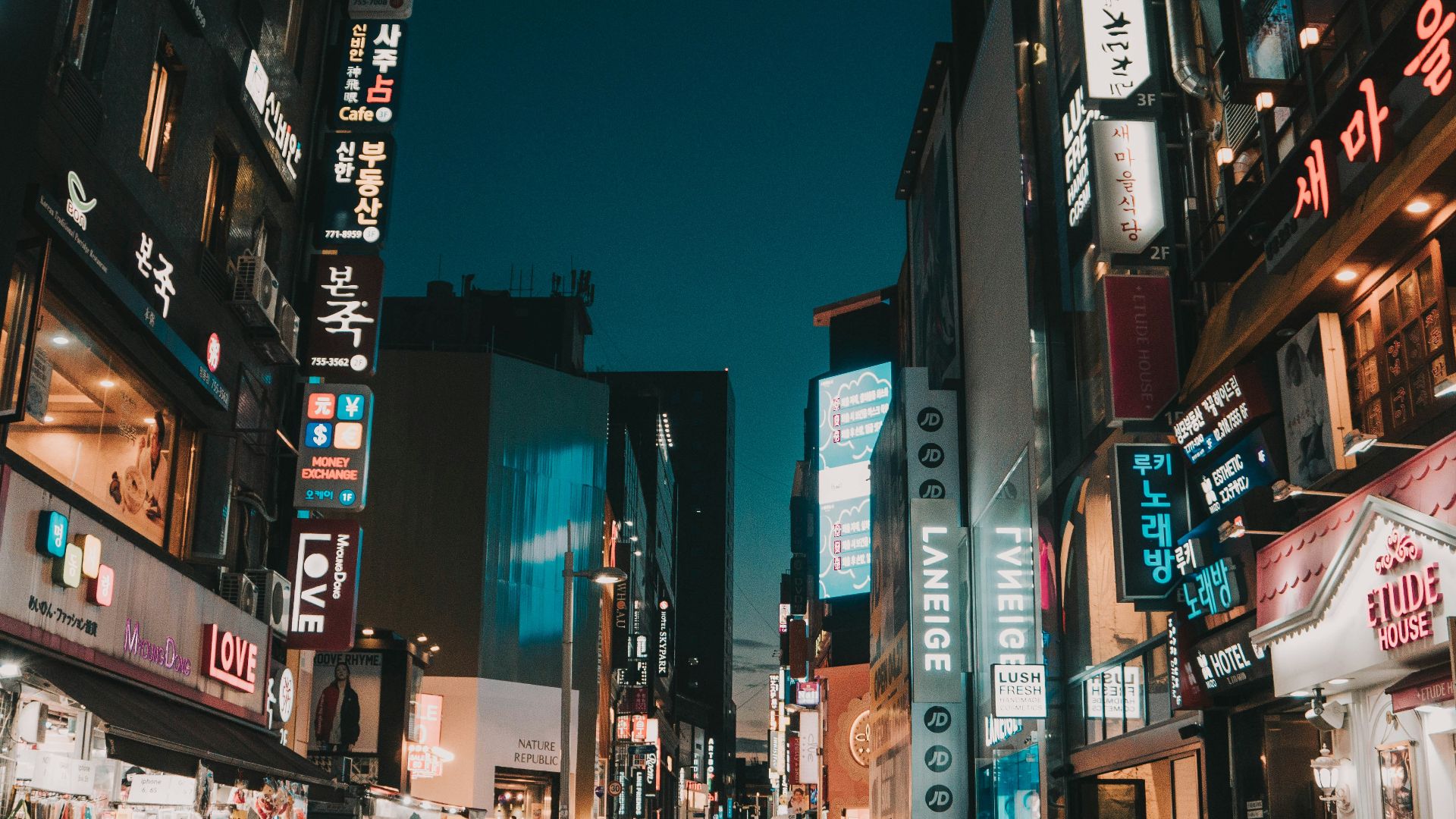 people walking between tall buildings