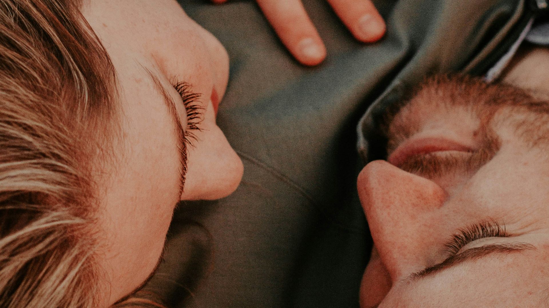 a woman stares into a man's eyes lovingly