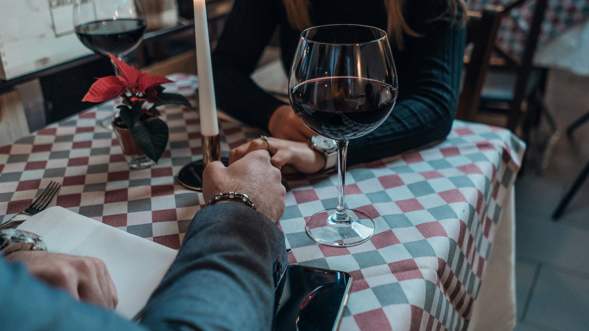 woman wearing black sweater holding hand with man wearing gray suit jacket