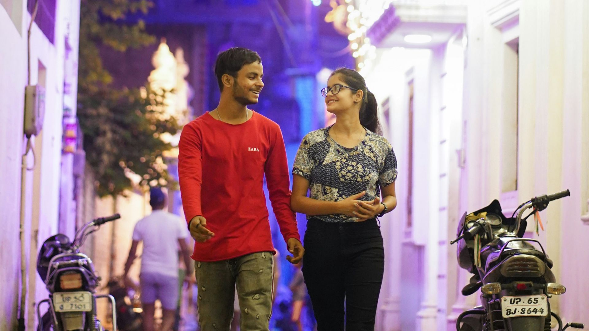 A man and a woman walking down a street at night
