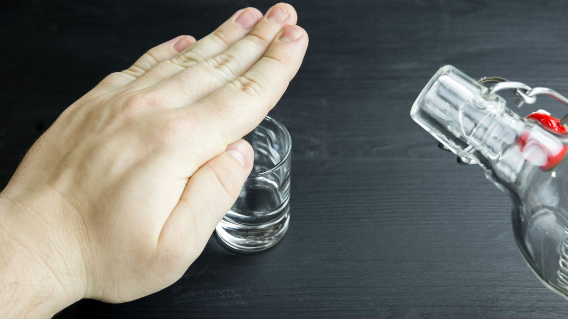 a hand reaching for a glass of water