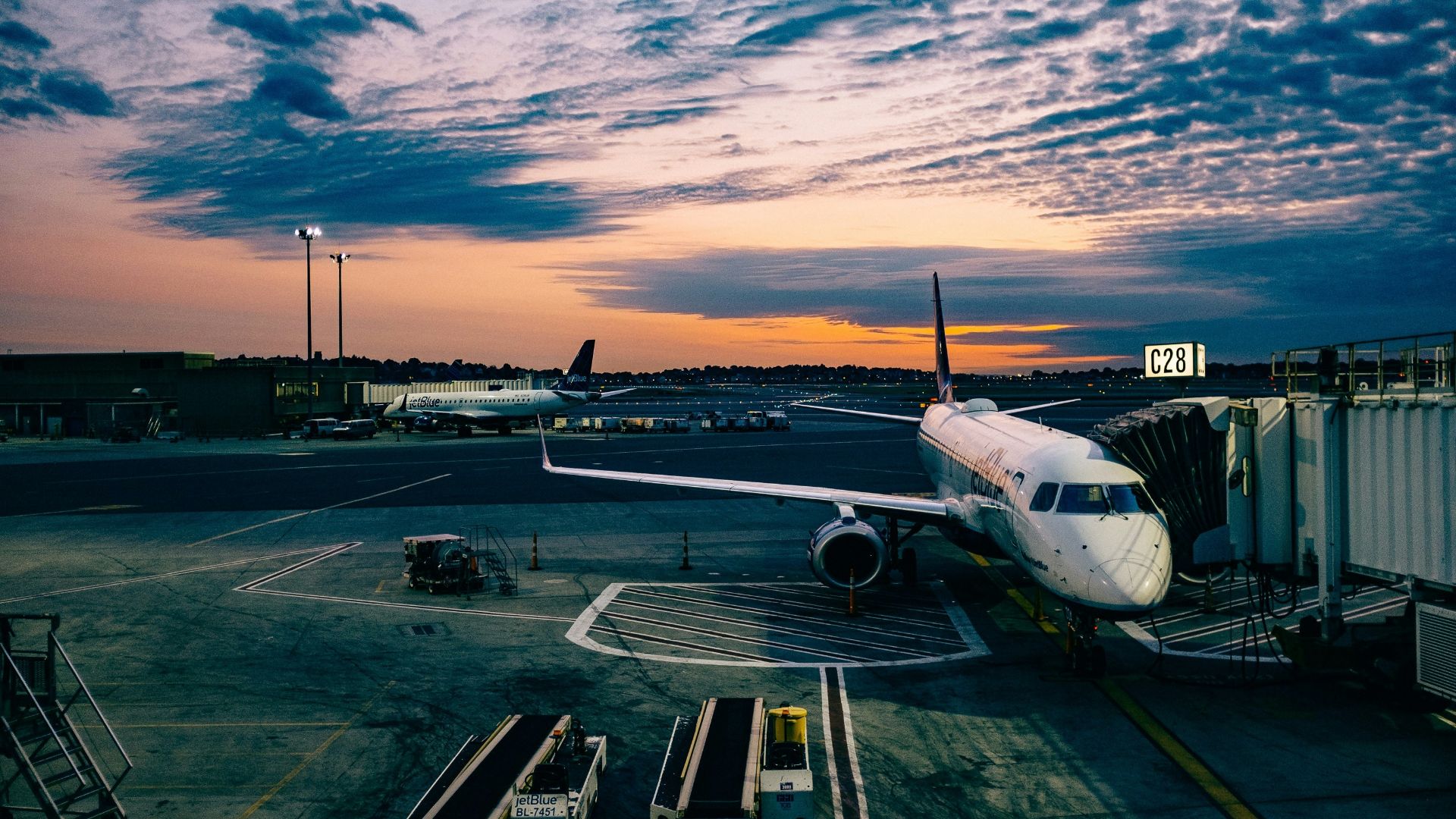 white airplane near trailers during sunset