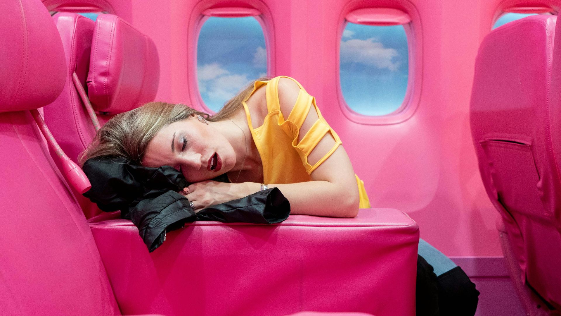 girl in yellow long sleeve shirt lying on red inflatable bed