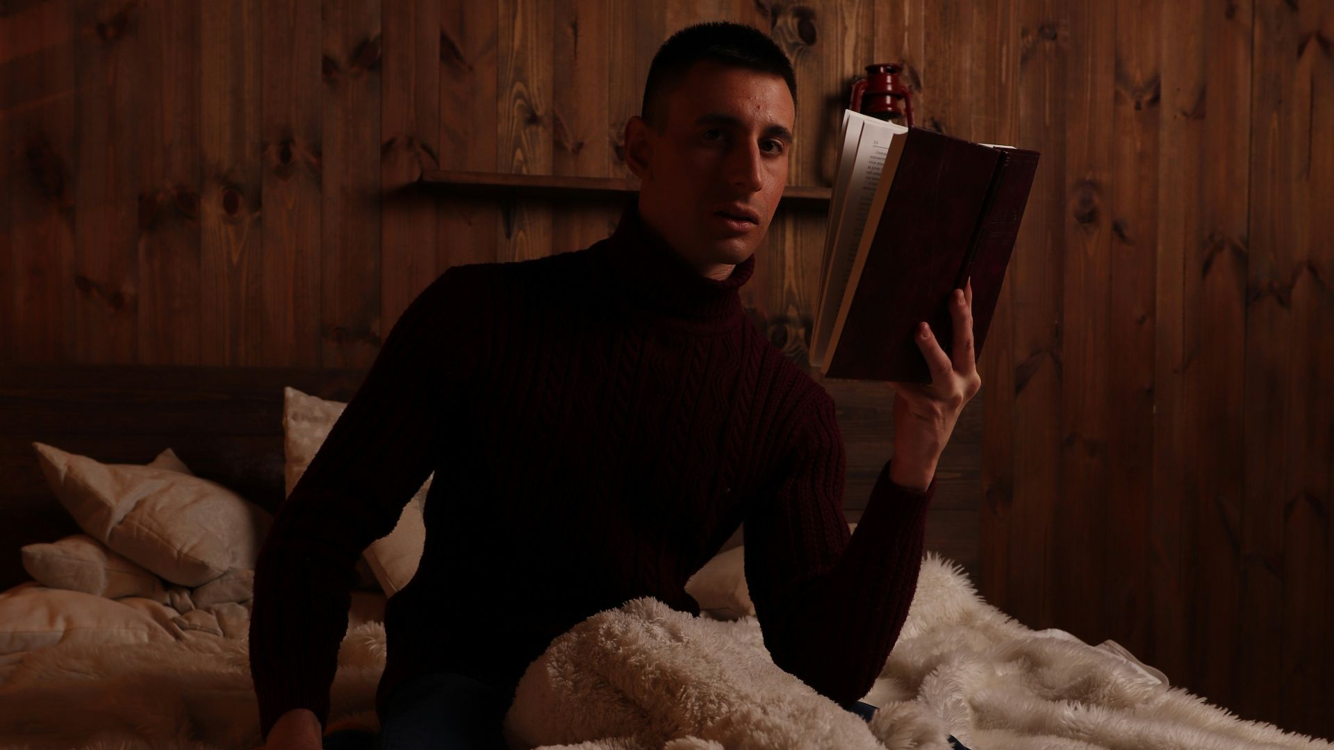 man in black long sleeve shirt sitting on bed