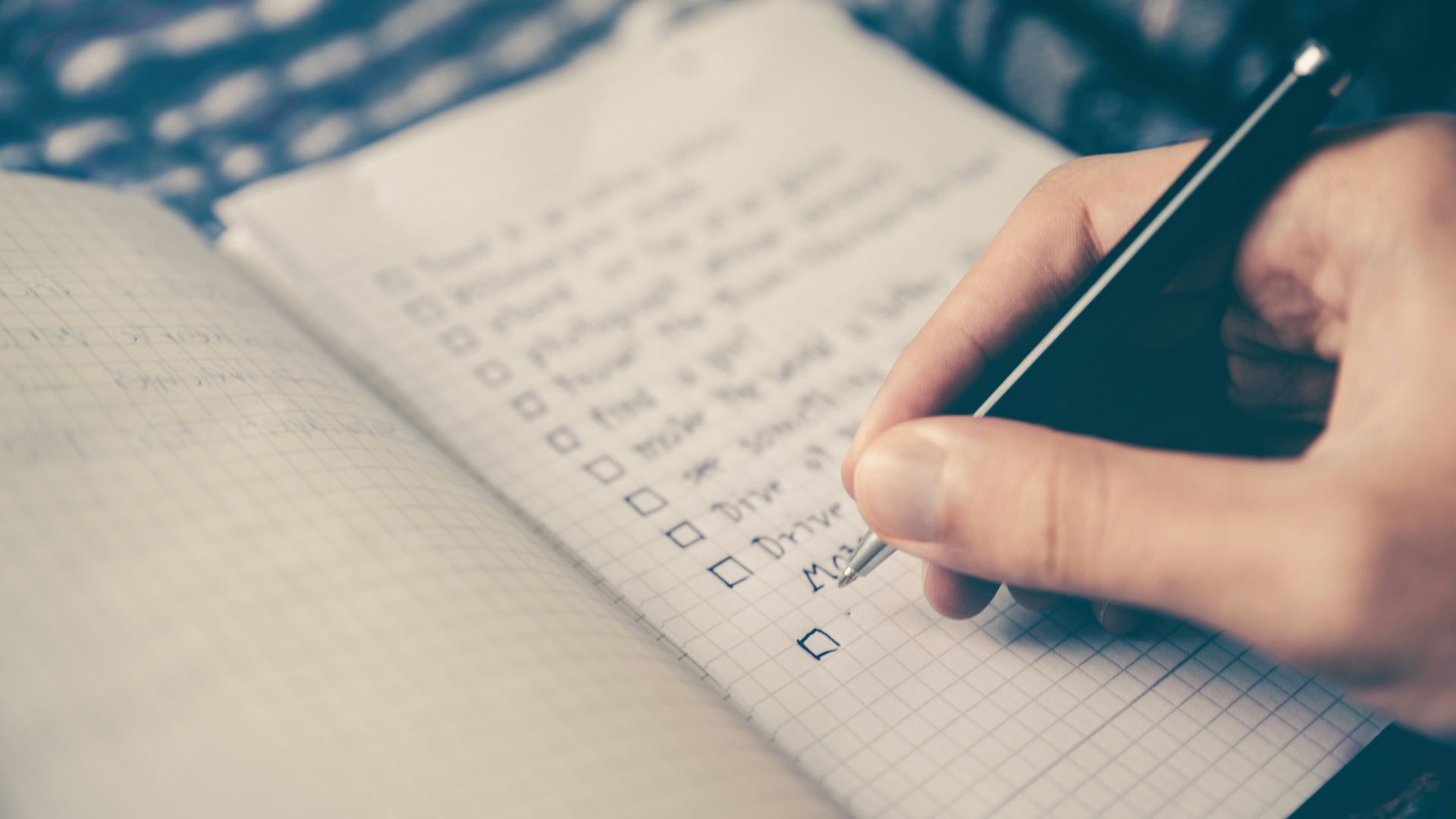 person writing bucket list on book