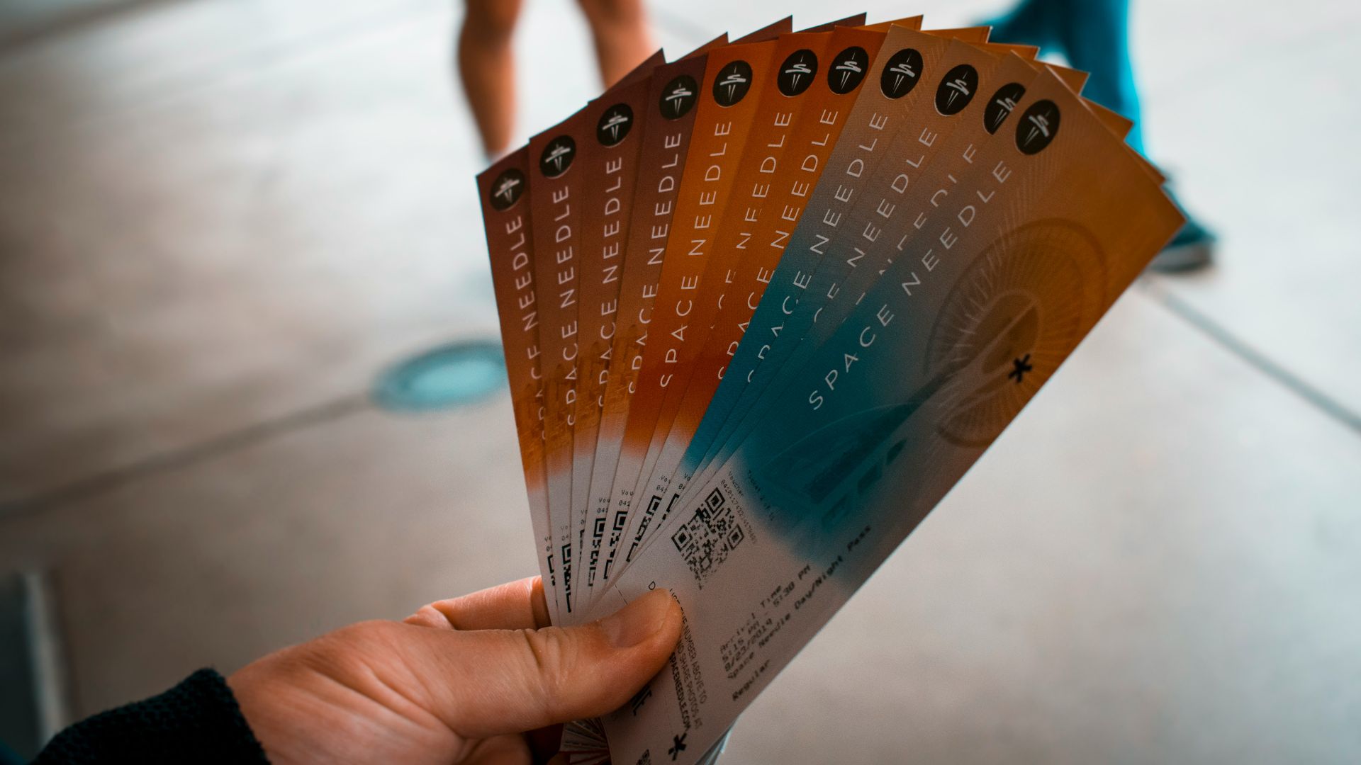 person holding brown, blue, and white tickets