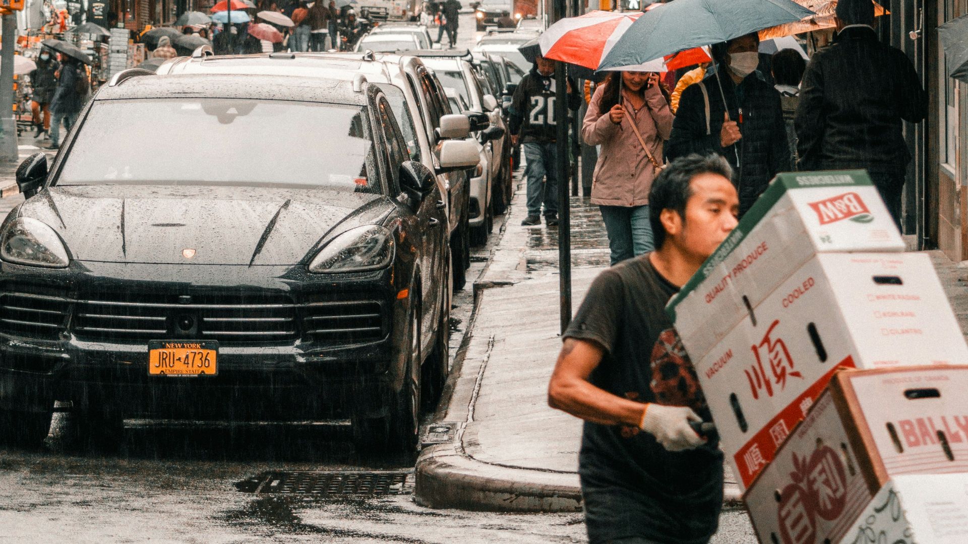 a man pushing a cart down a city street