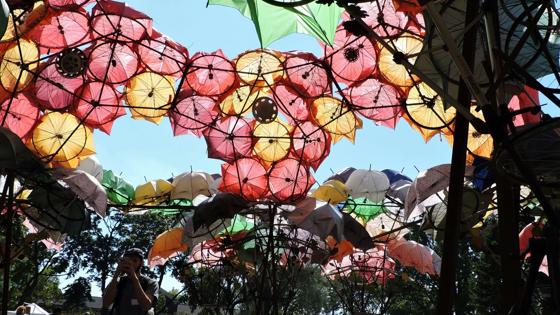 a person standing under a bunch of umbrellas