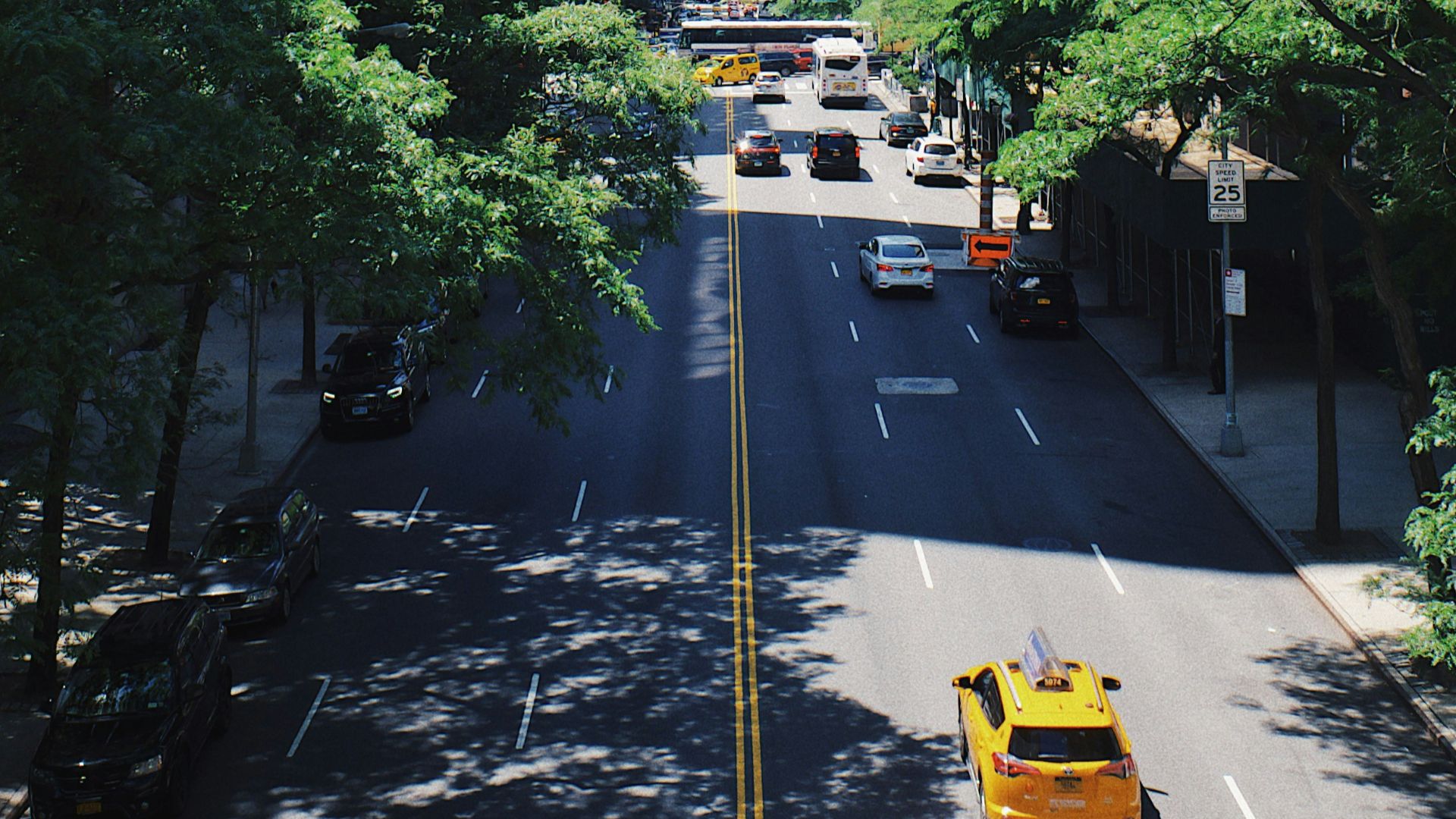 yellow car running on the street between the building during daytime