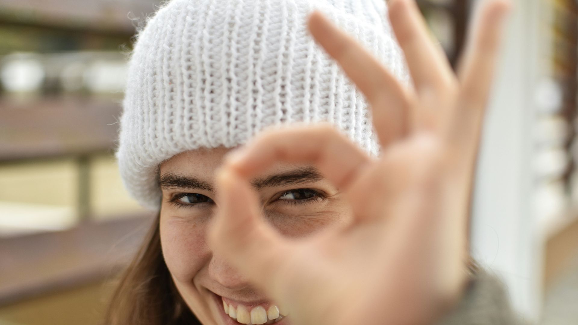 smiling woman wearing white knit cap