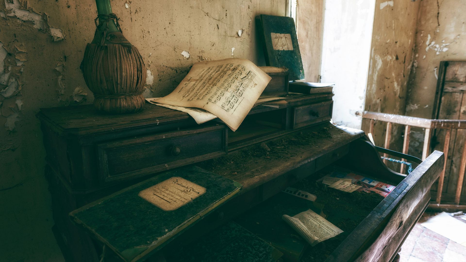 an old desk with a book and a vase on top of it