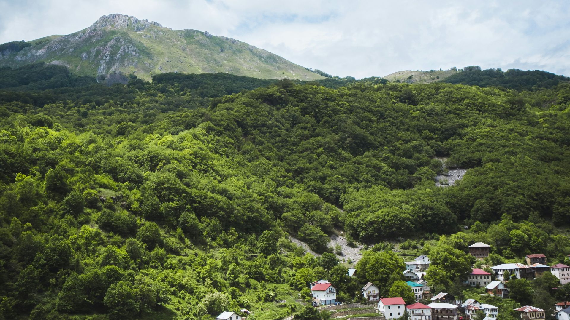 green mountain under white clouds during daytime