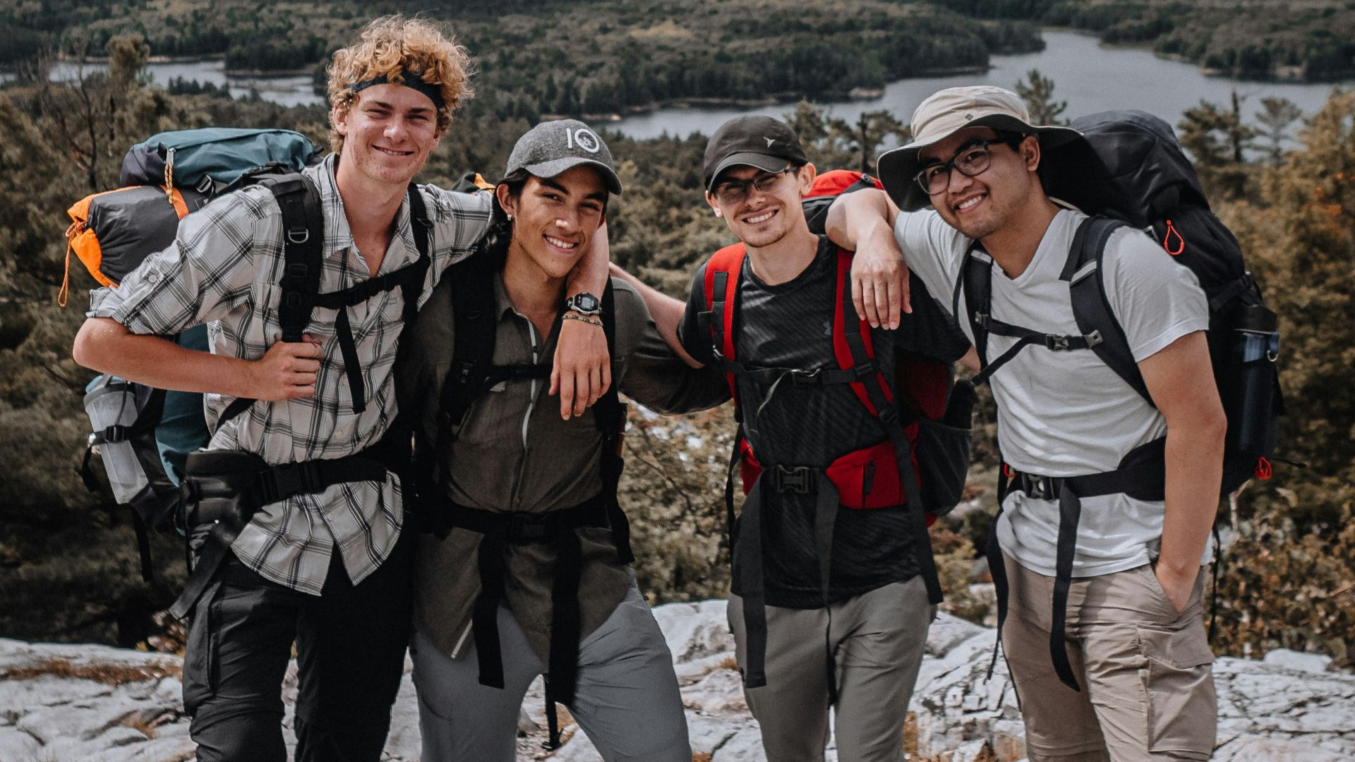 3 men standing on rocky mountain during daytime
