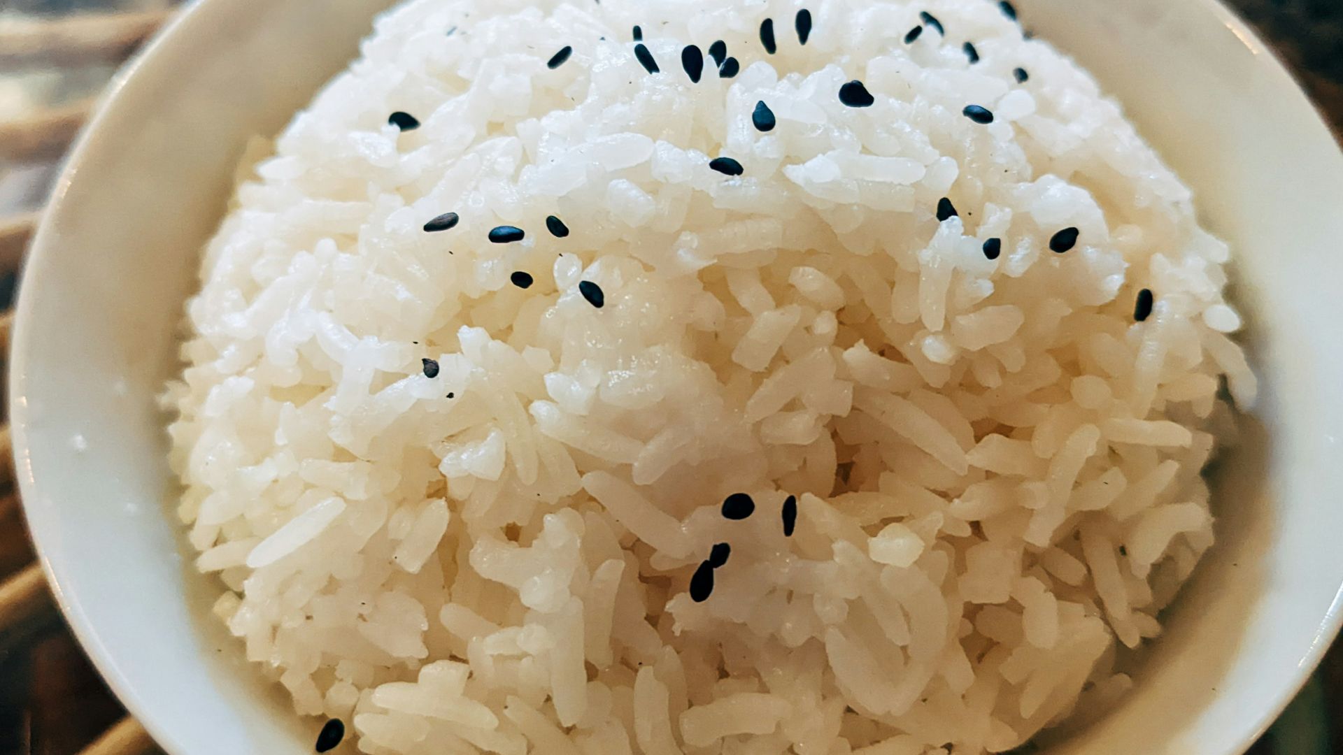 a bowl of white rice with black sesame seeds