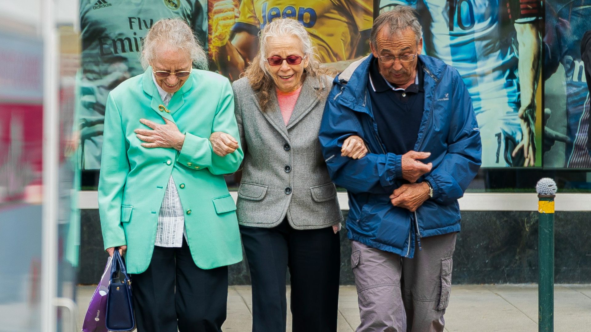 two women and man walking in the street during daytime