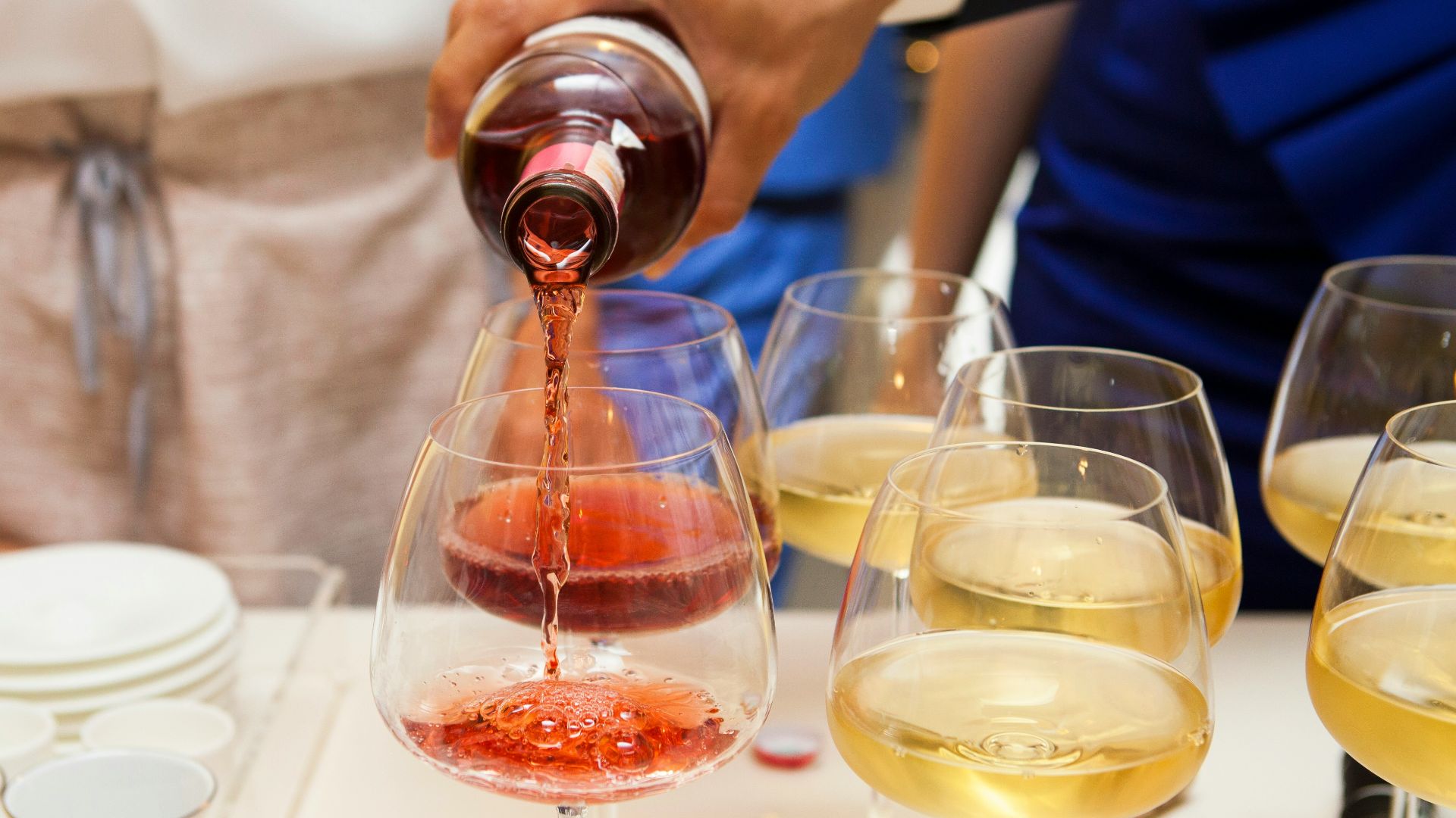 person pouring wine on wine glass