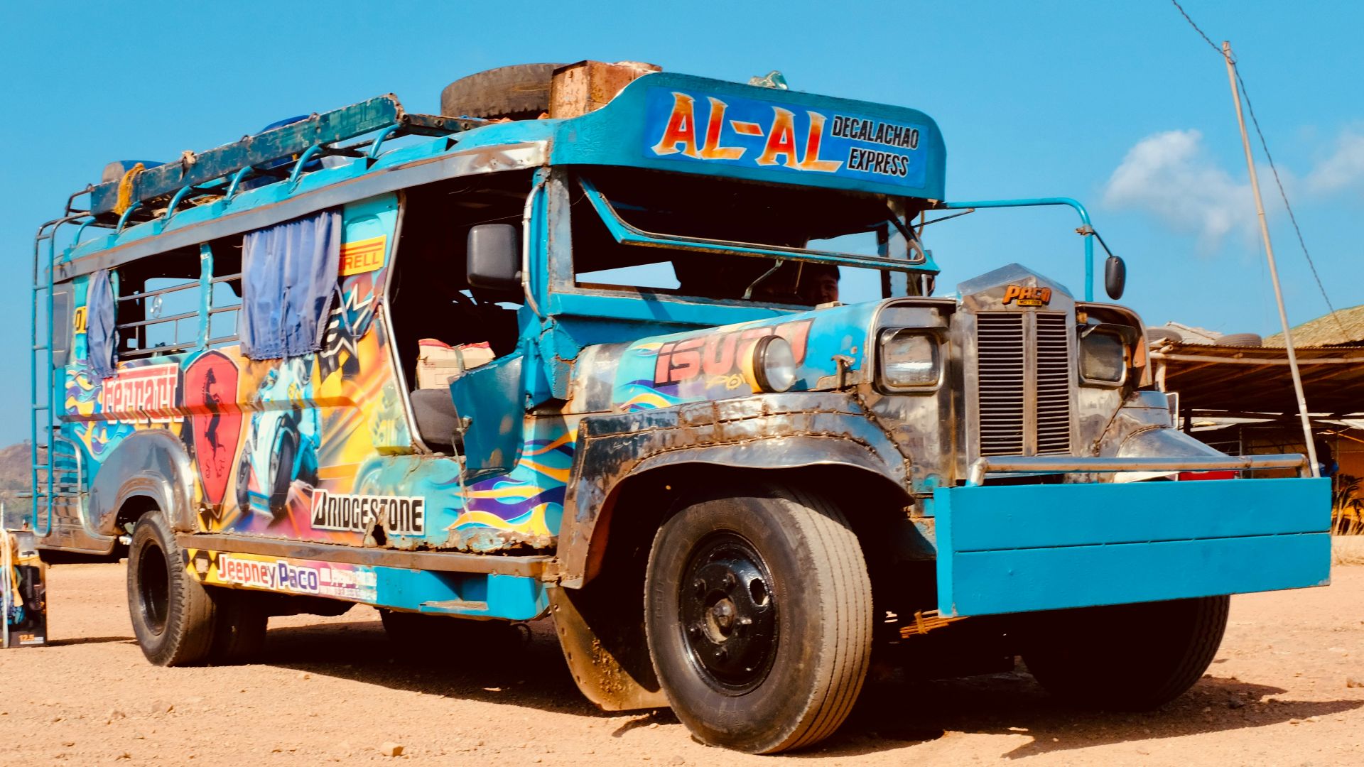 a blue bus parked on top of a dirt field