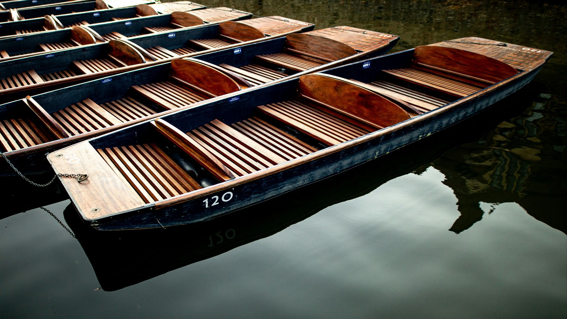 a row of wooden boats floating on top of a body of water