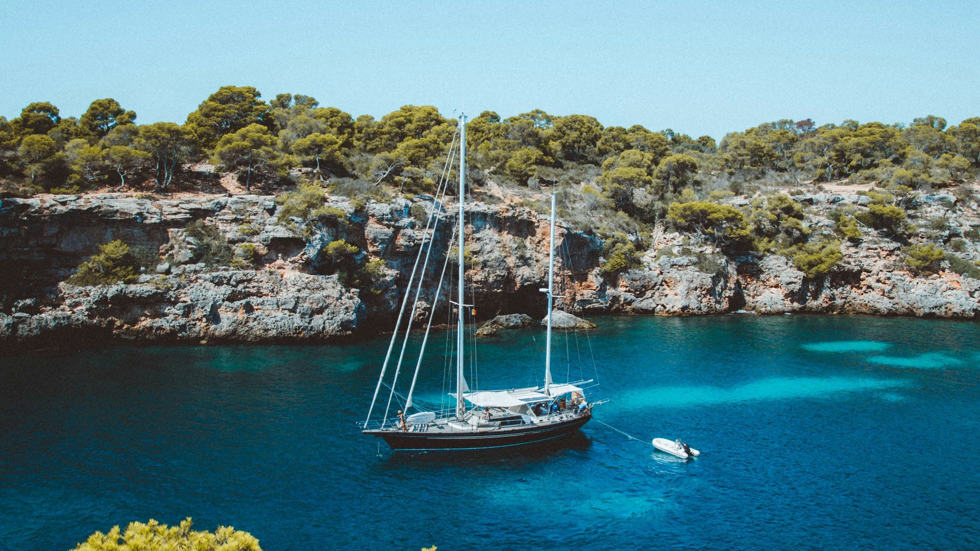 brown and white sailboat at middle of sea