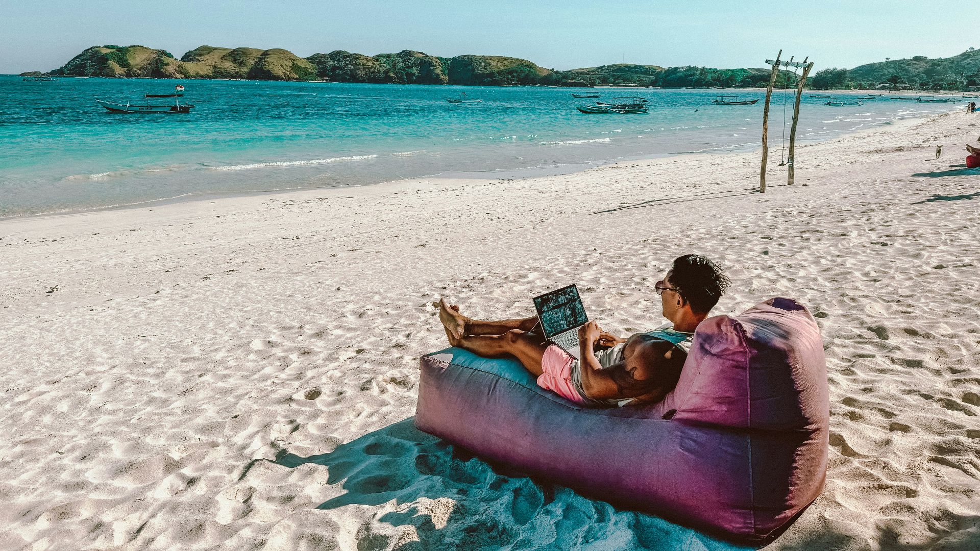 a man sitting on a bean bag on the beach