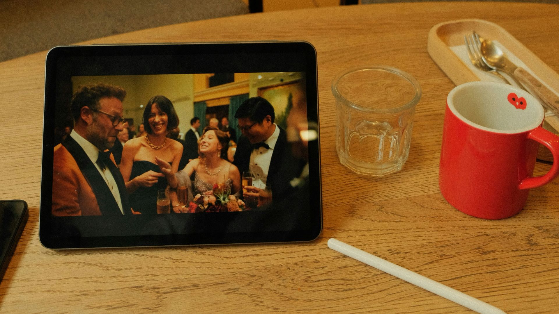 People watch a video on a tablet in a cafe.