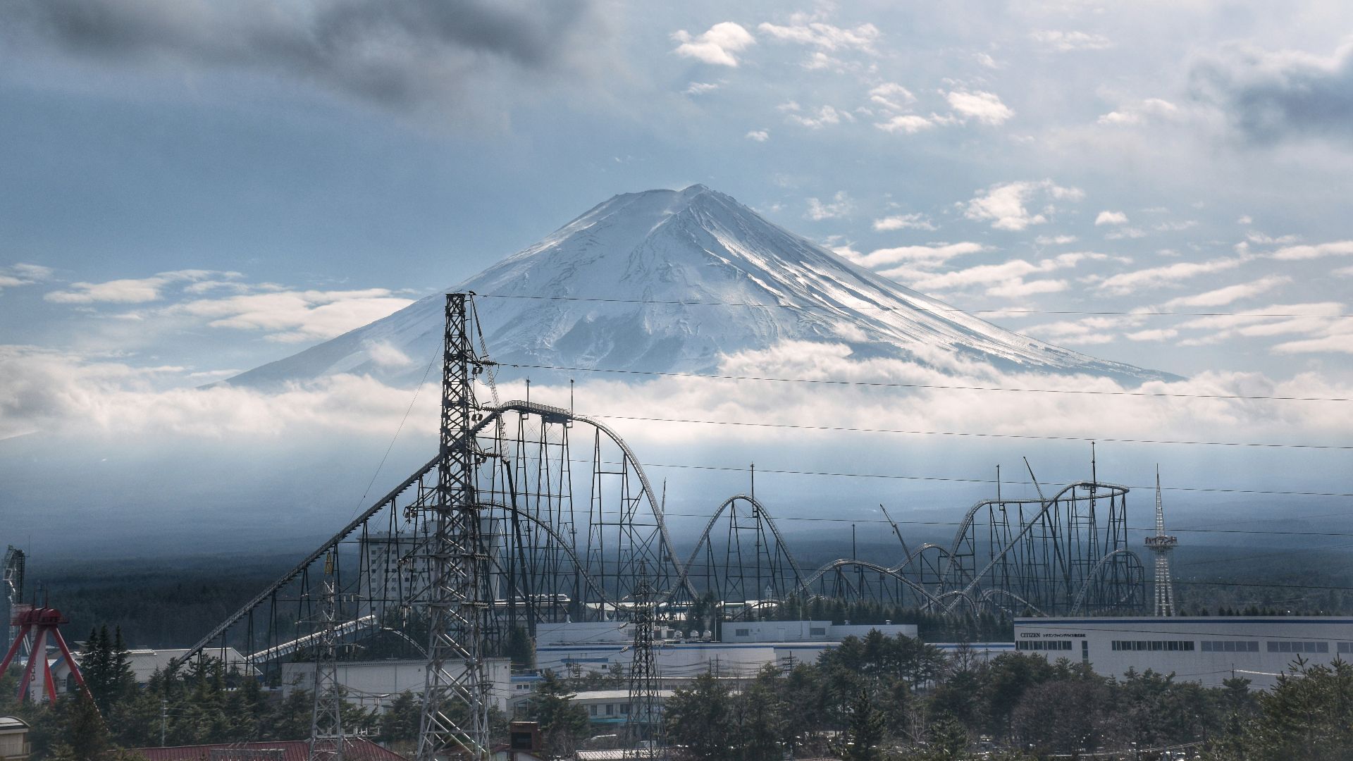 a roller coaster with a mountain in the background