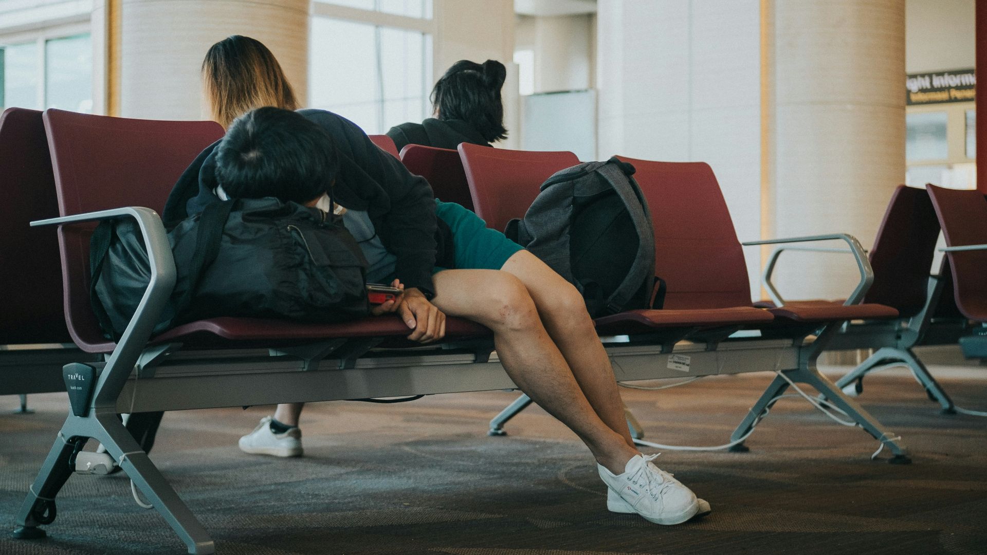 unknown person lying on brown bench indoors