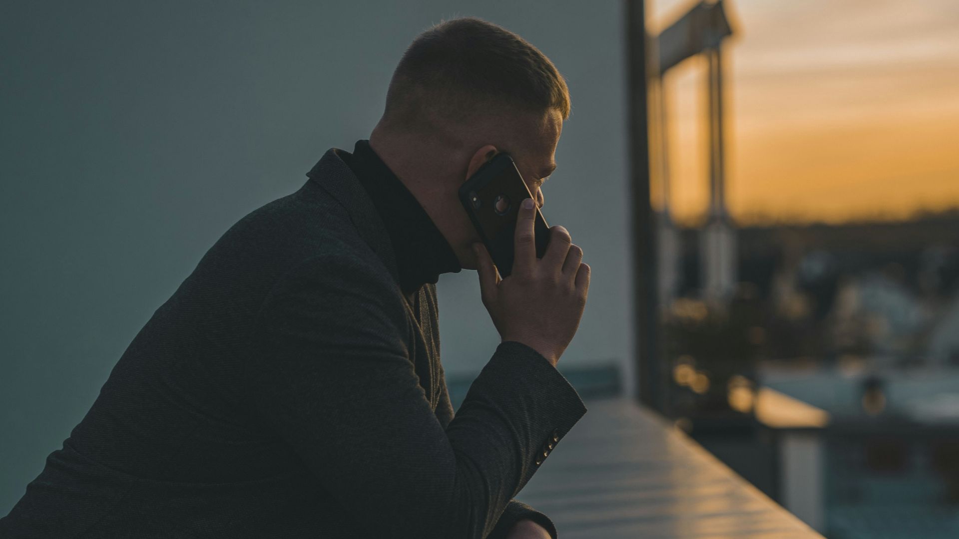 man in black long sleeve shirt sitting by the table