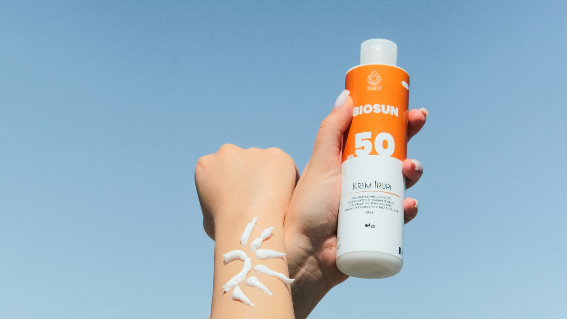 a person holding a bottle of sunscreen in their hand