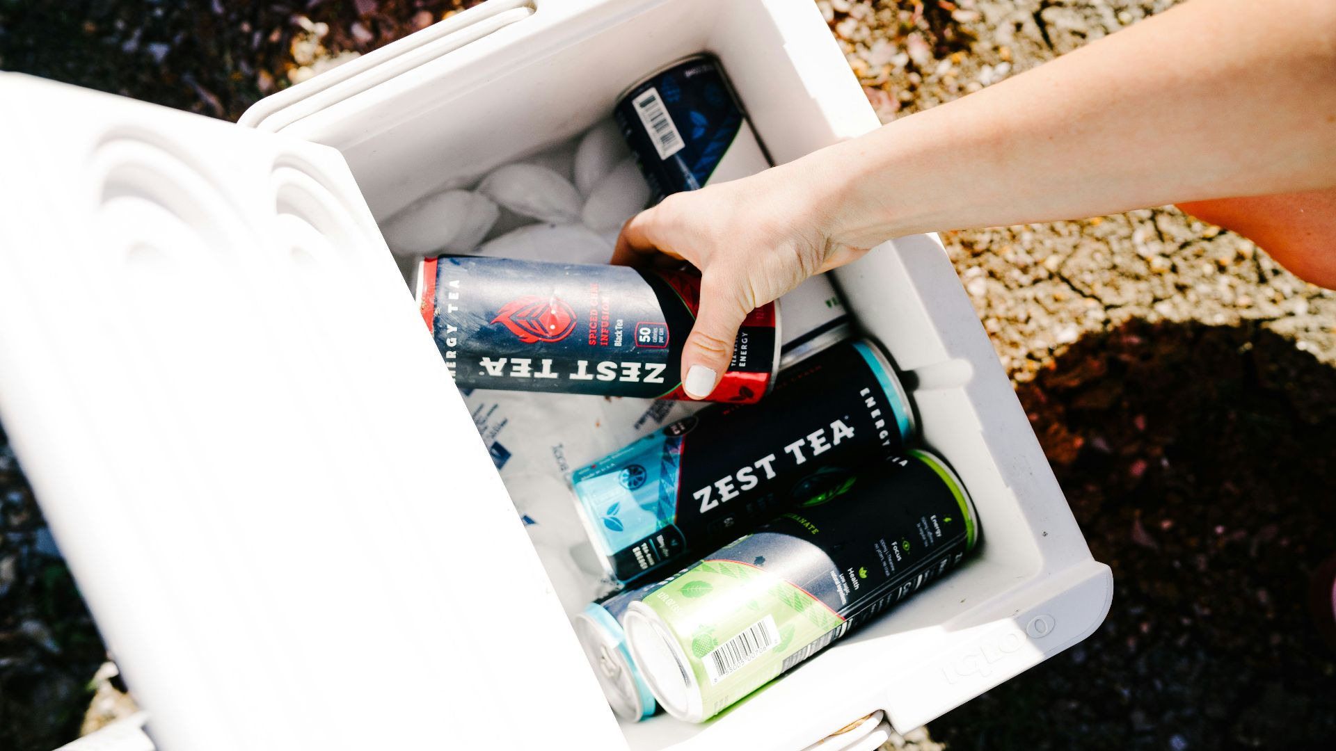 person holding green and red can