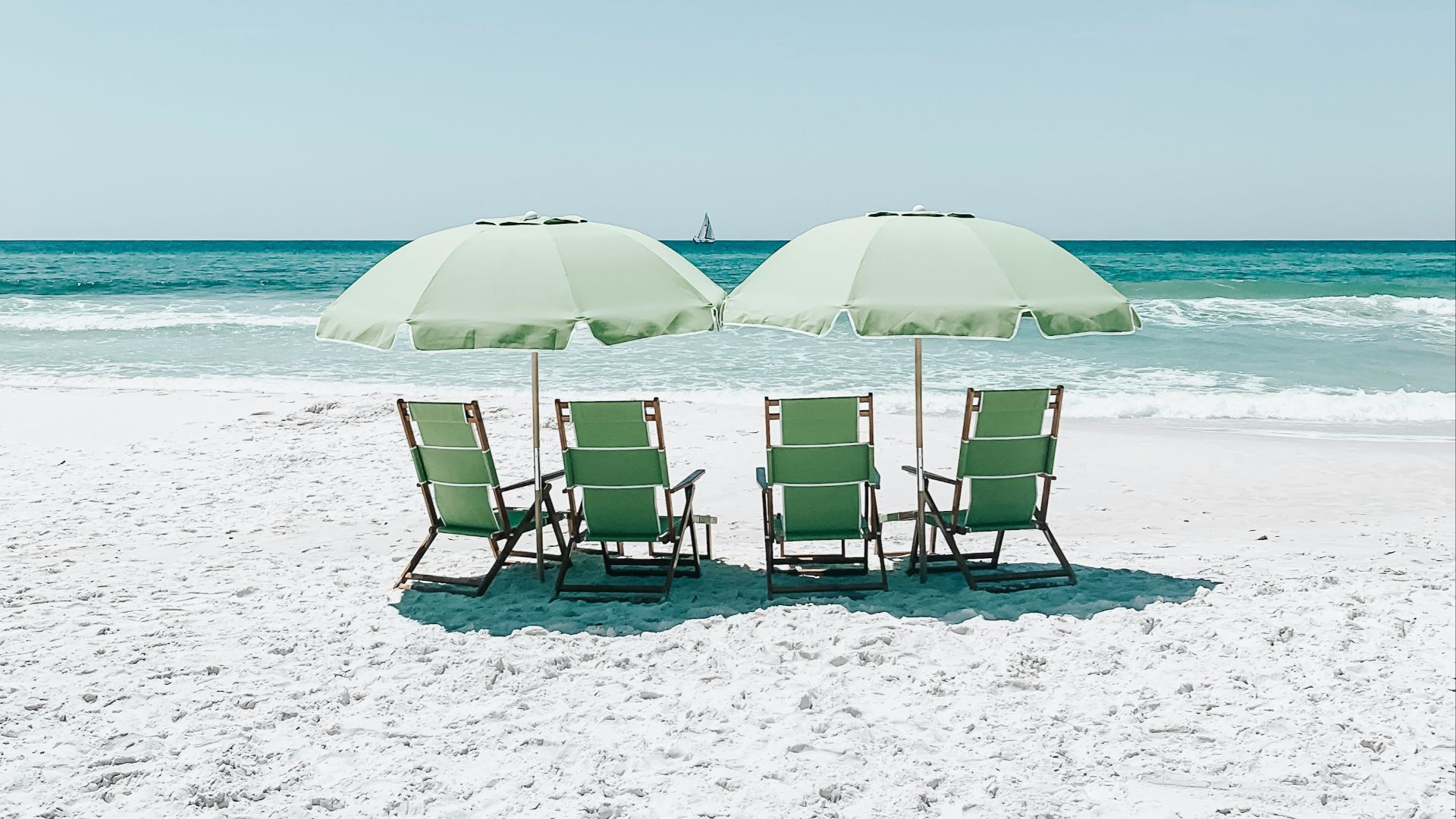 green chairs under umbrellas on shore