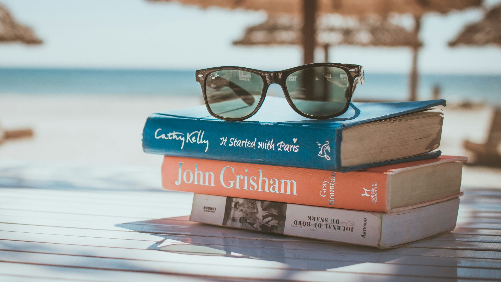 black framed Ray-Ban Wayfarer sunglasses on top of book