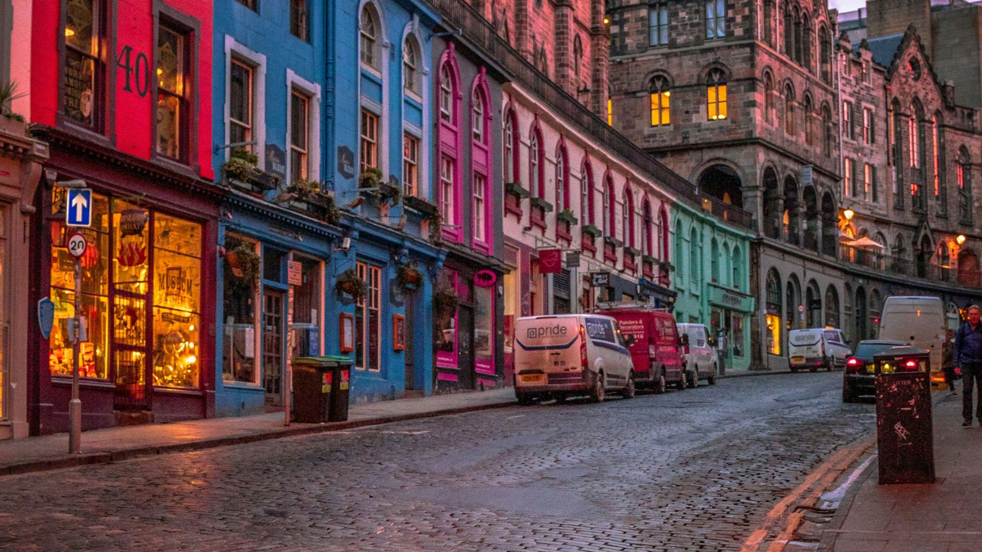 people walking on sidewalk near red concrete building during daytime